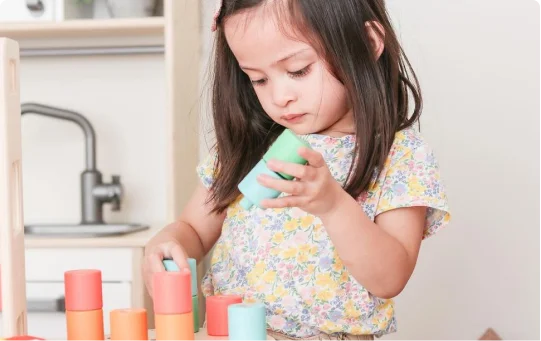 Child with Lovevery stacking toy