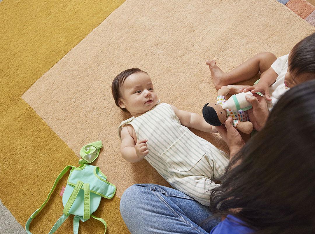 baby playing on ground with family